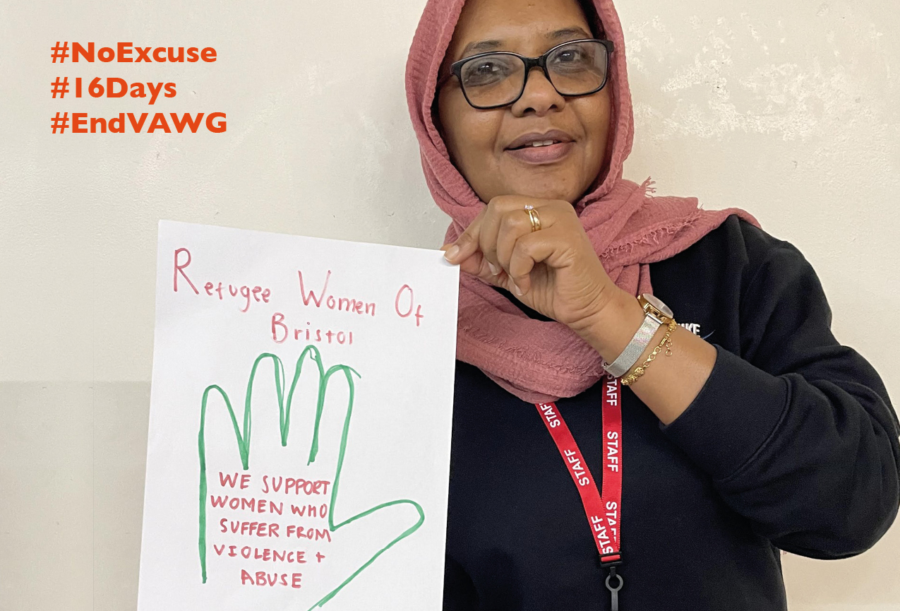 Staff member from Refugee Women of Bristol holding their pledge to support women who suffer from violence and abuse